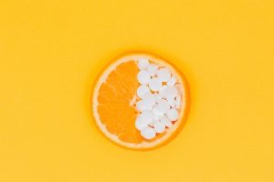 Kolut narandže na čijoj se polovini nalaze tablete vitamina C.