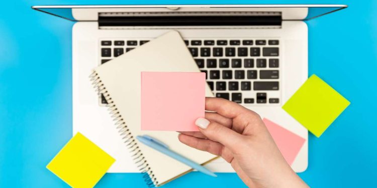 Računar i papirići za beleške.