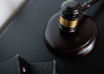 Sudijski čekić na crnom stolu u sudnici.