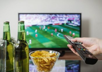 Fudbalska utakmica na TV-u, dve flaše piva i čips na stočiću