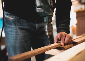 Čovek buši drvenu letvu