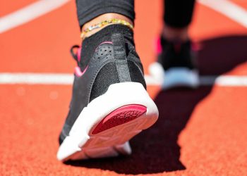 Crna patika sa belim đonom i ružičastim detaljima na tartan stazi