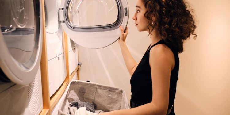 zena pakuje ves u masinu za susenje