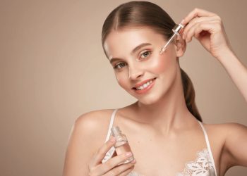 devojka nanosi esenciju za lice