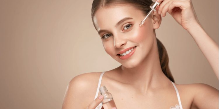 devojka nanosi esenciju za lice