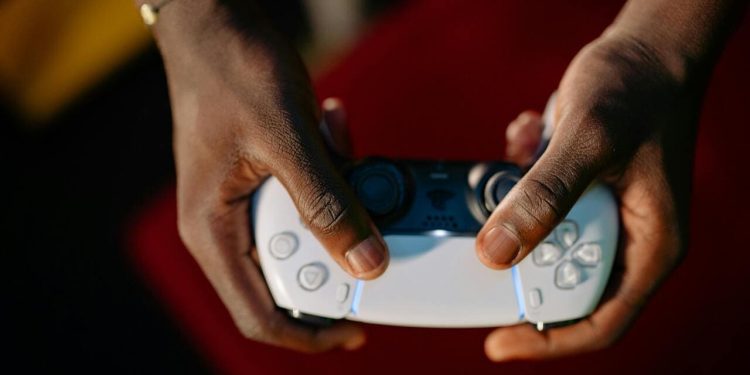 Ruke drže beli kontroler za video igru