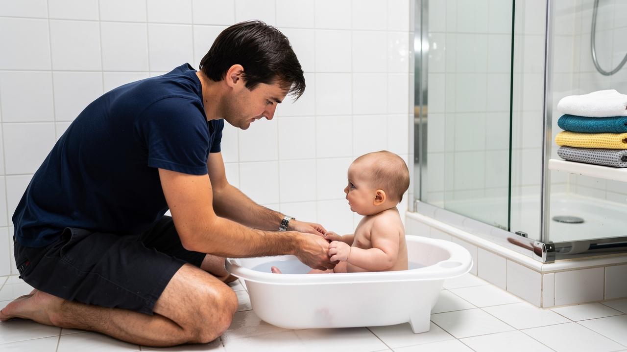 Ruke slažu bele peškire pored bočice sa pumpicom na lavabo